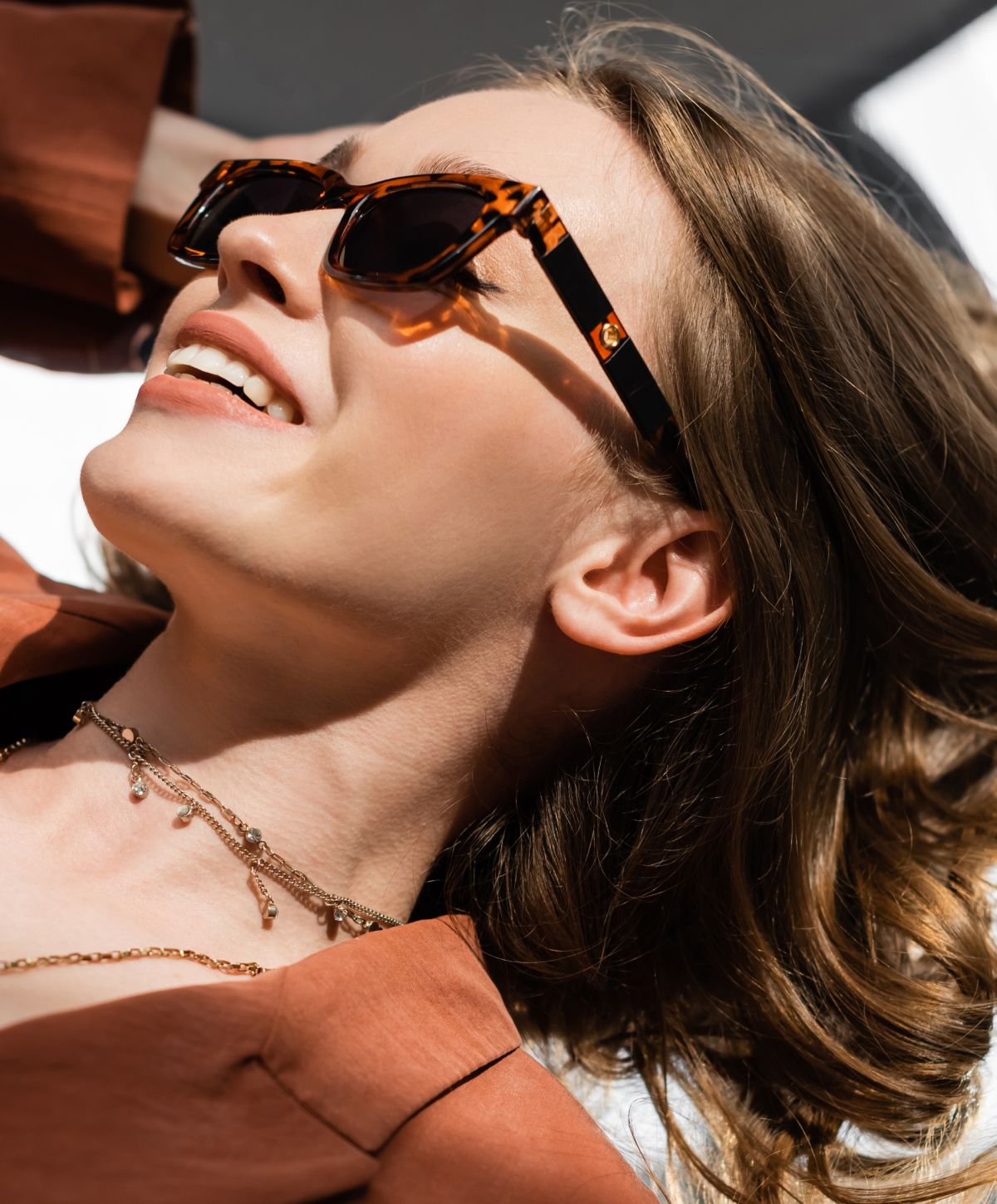 Woman in sunglasses with elegant hairstyle outdoors.