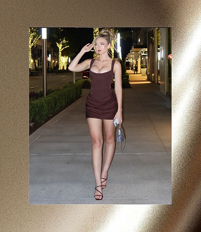 Woman in stylish dress posing at night.
