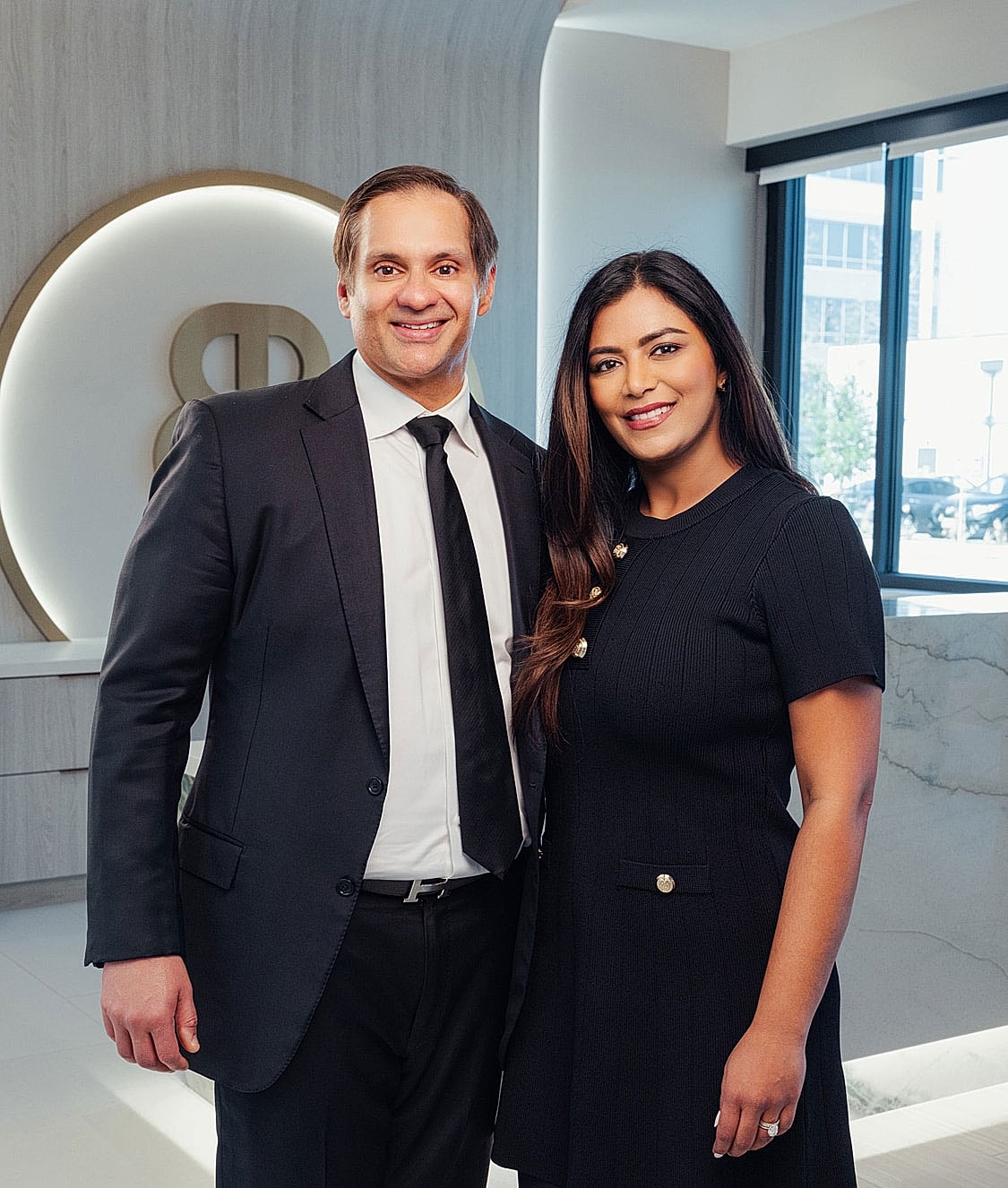 Professional portrait of two smiling individuals.
