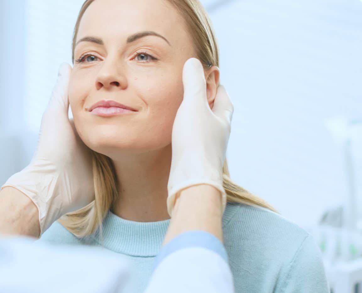 Plastic / Cosmetic Surgeon Examines Beautiful Woman's Face, Touches it with Gloved Hands, Inspecting Healed Face after Plastic Surgery with Amazing Results.