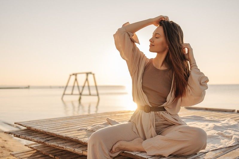 Woman enjoying sunset on beachside platform.