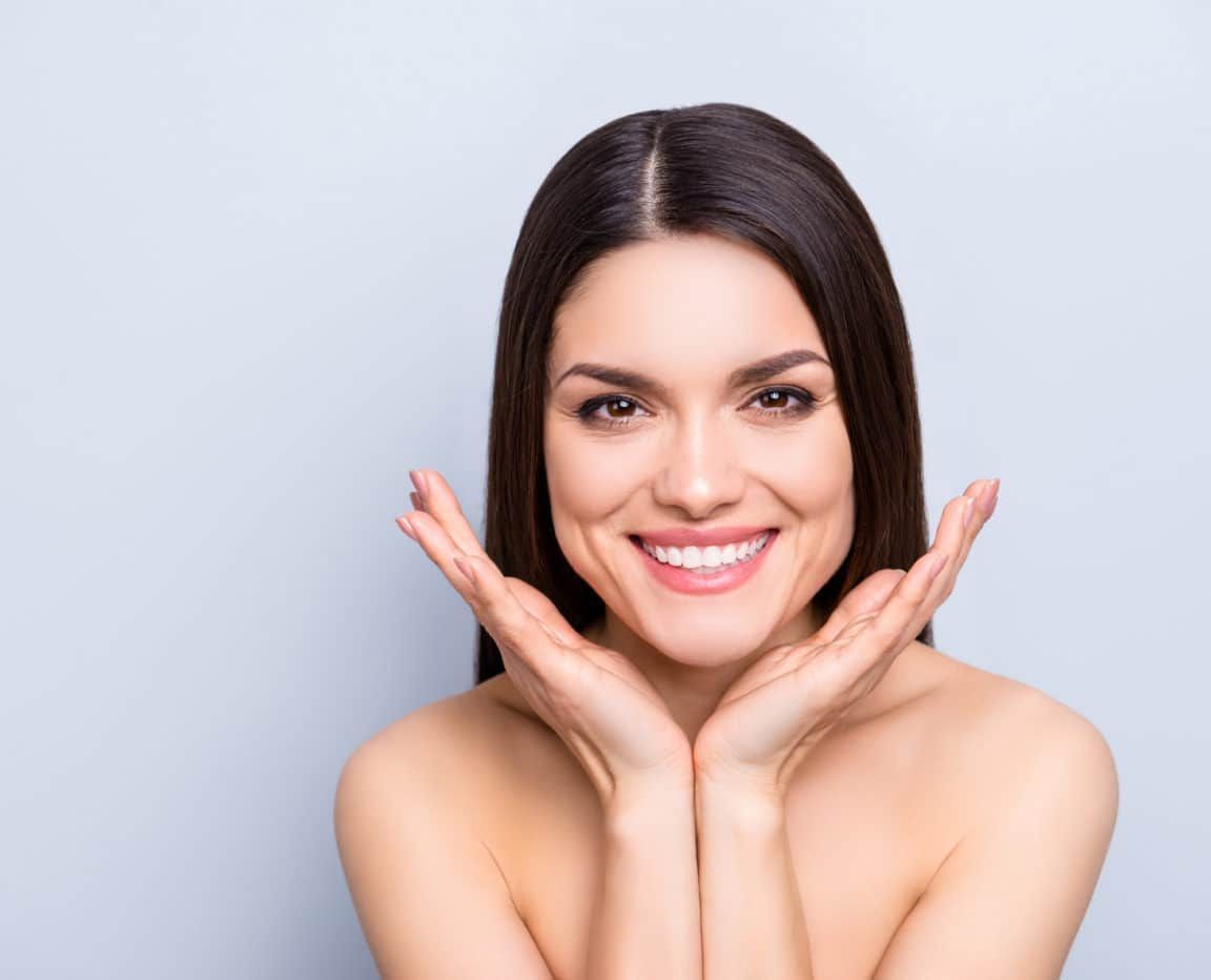 BOTOX BOOST - woman with large smile framing face with hands